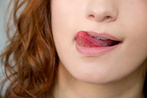 Người phụ nữ liếm môi do đắng miệng vào mỗi buổi sáng